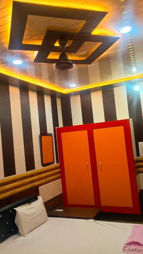 a bedroom with orange cabinets and a striped wall at vaidehi homlee premium stay, 3kms from Shri Ram janmbhoomi, Ayodhya in Faizābād