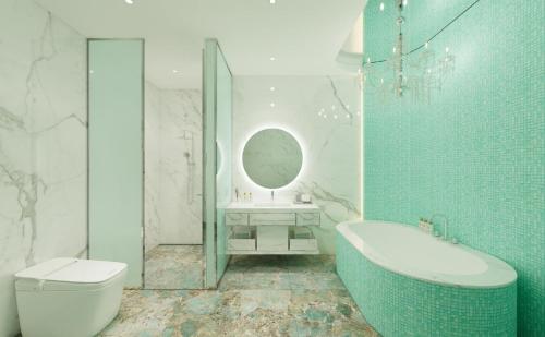 a bathroom with a tub and a toilet and a sink at The Siena PRIMO in Seogwipo