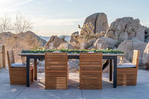 a table with chairs and a table with plants on it at Cozy Retreat Amidst Boulders in Yucca Valley