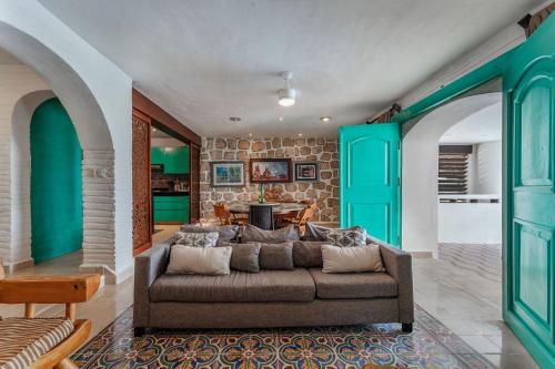 a living room with a couch and green doors at La Casa Del Velero, Beachfront in Chicxulub