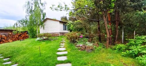 a garden with a stone path in front of a house at Forest Hide Tiny House in Covasna