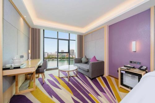 ShaoguanにあるLavande Hotel Shaoguan Bainian East Street Fengcai Buildingの紫と黄色の部屋があるホテルの部屋