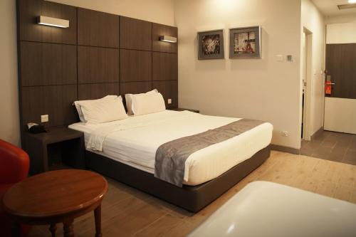 a hotel room with a bed and a table at Dreamtel Jakarta in Jakarta
