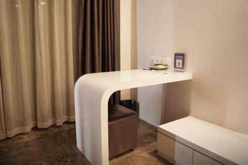 a white desk in a room with curtains at Dreamtel Jakarta in Jakarta