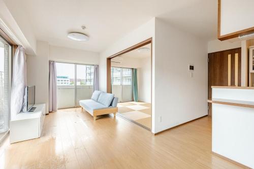 a living room with a chair and a mirror at Jintai House601 in Shiobaru