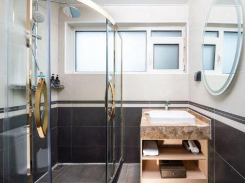 une salle de bain avec un lavabo et une douche dans l'établissement VX Hotel Beijing Daxing Wufutang Metro Station Zhongke Dianshanggu, à Pékin