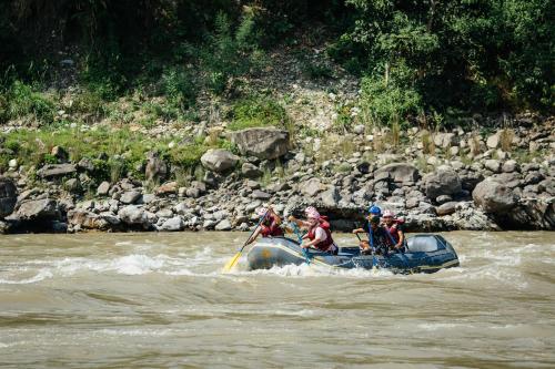 a group of people in a raft on a river at Riverside Springs Resort in Chitwan