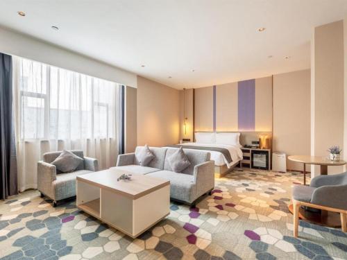 pokój hotelowy z łóżkiem, kanapą i krzesłami w obiekcie Lavande Hotel Zhongshan Shiqi Daxinxinduhui North Zhongshan Station w mieście Zhongshan