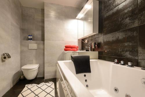 a bathroom with a white tub and a toilet at Aida 7 Apartement in Pärnu