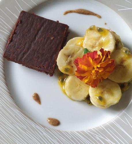 a white plate with a piece of chocolate and a flower at Gîte du Soleil Levant - Drôme des collines in Bren
