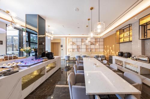 a restaurant with a long table and chairs at 厦门火车站明发广场亚朵酒店 in Xiamen