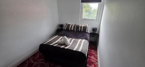 a small bedroom with a bed with a window at National Smokehouse Hotel Coleraine in Coleraine