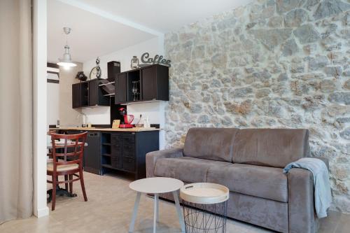 un salon avec un canapé et une cuisine dans l'établissement À 1km Plage du Midi et Palais des Festivals - Appartement Centre Cannes avec Cour Extérieur Privée, à Cannes