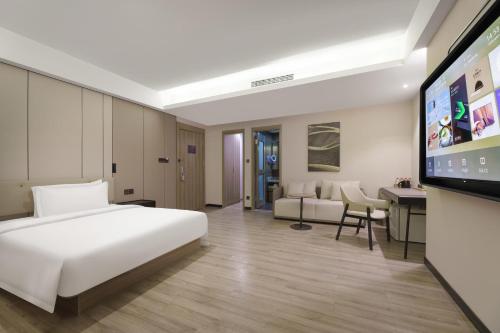 a hotel room with a bed and a tv at Atour Hotel Xi'an Bell Tower North Street Station in Xi'an