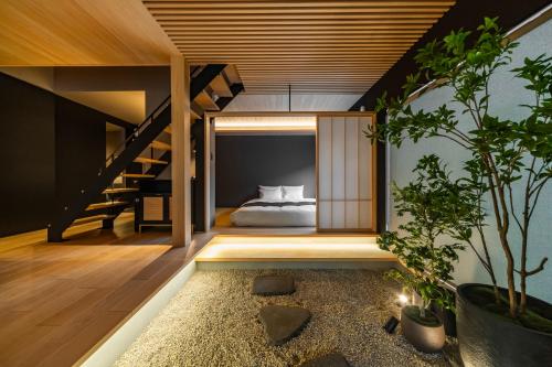 a bedroom in a house with a bed and a staircase at GLOWVIA Takayama-showa in Takayama