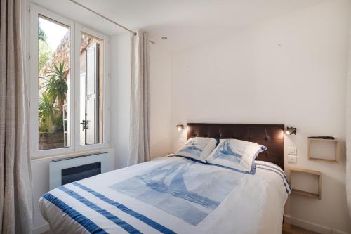 une chambre avec un lit et une fenêtre dans l'établissement À 1km Plage du Midi et Palais des Festivals - Appartement Centre Cannes avec Cour Extérieur Privée, à Cannes
