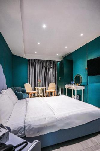 a bedroom with a large bed and blue walls at Sunny Day Hotel in Hong Kong
