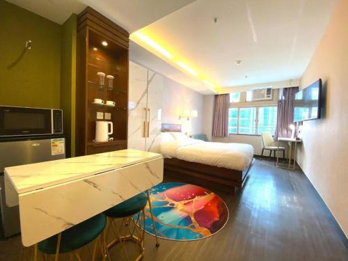 a hotel room with a bed and a desk in it at Sunny Day Hotel in Hong Kong