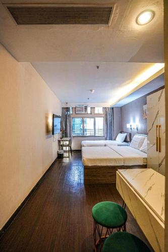a hotel room with two beds and a green chair at Sunny Day Hotel in Hong Kong