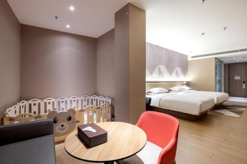 a hotel room with two beds and a table and chairs at Borrman Hotel Korla Peacock River in Korla