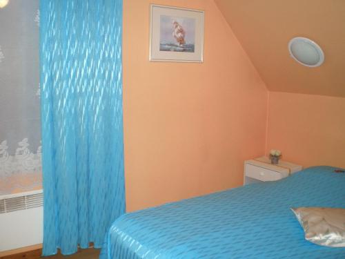 a bedroom with a bed and a blue curtain at Jannseni Accommodation in Pärnu