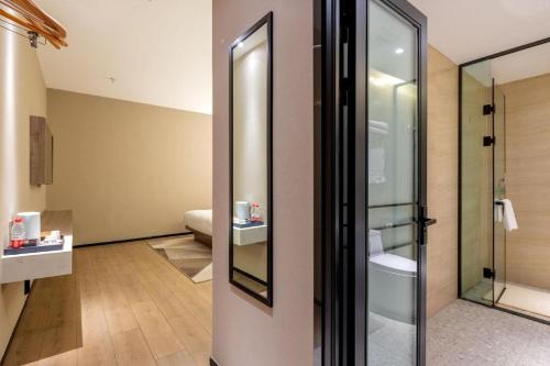 a bathroom with a shower and a mirror at Borrman Hotel Korla Peacock River in Korla