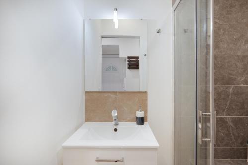 une salle de bain avec un lavabo blanc et une douche dans l'établissement À 1km Plage du Midi et Palais des Festivals - Appartement Centre Cannes avec Cour Extérieur Privée, à Cannes