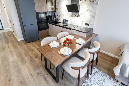 アスタナにあるКвартира с душойの木製のテーブルと椅子のあるキッチンとダイニングルーム