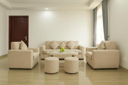 a living room with a couch and two chairs and a table at Try Residence, The Elysée Koh Pich in Phnom Penh