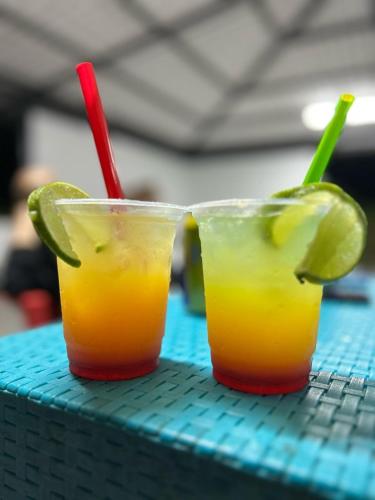 two cocktails sitting on a table with lime and red straws at Finca Villa Julia in La Vega