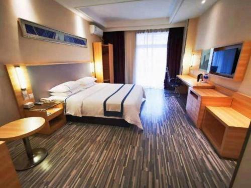 a hotel room with a bed and a television at City Comfort Inn Hotel Wuhan Optics Valley Square Metro Station Zhongnan Minzu University in Wuhan