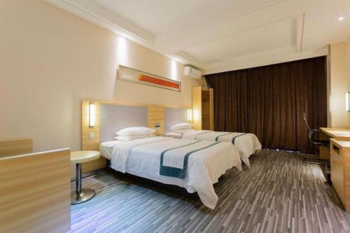 a hotel room with two beds and a sink at City Comfort Inn Hotel Wuhan Optics Valley Square Metro Station Zhongnan Minzu University in Wuhan