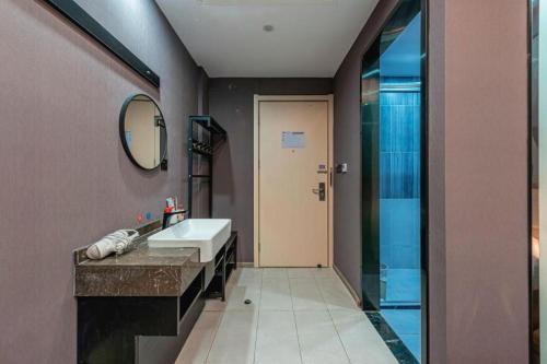 une salle de bain avec un lavabo, un miroir et une douche dans l'établissement Thank Inn Hotel Zhejiang Ningbo Haishu Yinzhou Avenue Metro Station, à Ningbo