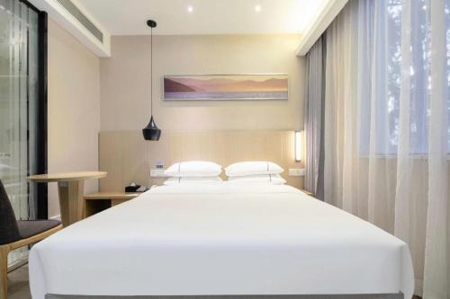 Ένα ή περισσότερα κρεβάτια σε δωμάτιο στο City Comfort Inn Wuhan Xudong Street Wangjiadun Metro Station