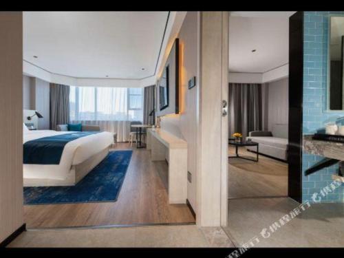 a hotel room with a bed and a living room at Echarm Hotel Shenzhen World Exhibition and Convention Center in Shenzhen