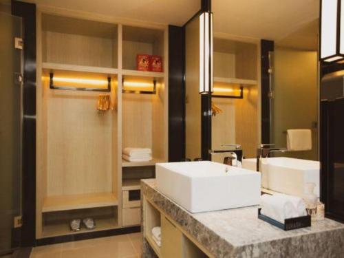 a bathroom with a sink and a large mirror at Echarm Hotel Shenzhen World Exhibition and Convention Center in Shenzhen