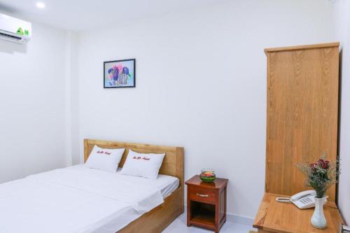 a bedroom with a bed and a phone and a table at Ha My Hotel in Ho Chi Minh City
