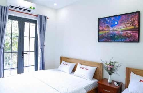 a bedroom with two beds and a window at Ha My Hotel in Ho Chi Minh City