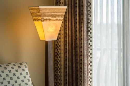 a lamp sitting next to a window with a curtain at Aulani, Disney Vacation Club Villas in Kapolei