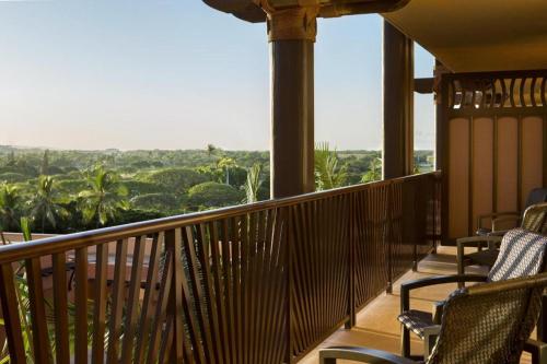 a balcony with chairs and a view of the jungle at Aulani, Disney Vacation Club Villas in Kapolei