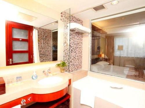 a bathroom with a sink and a tub and a shower at Xiamen Jingmin Central Hotel in Xiamen