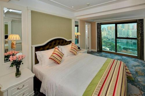 a bedroom with a large bed with a large window at Xiamen Jingmin Central Hotel in Xiamen