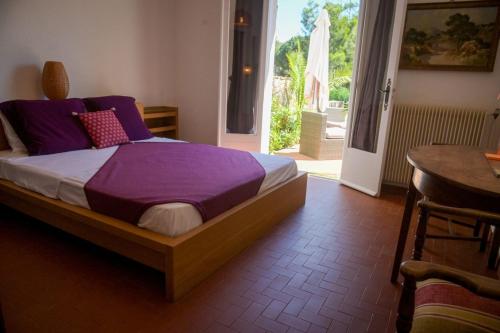 - une chambre avec un lit avec des draps violets et une table dans l'établissement Nina - Splendide villa, domaine privé, jardin magnifique, rooftop et plage à pied, à Porticcio