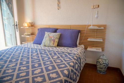 une chambre avec un lit avec une couette bleue et blanche dans l'établissement Nina - Splendide villa, domaine privé, jardin magnifique, rooftop et plage à pied, à Porticcio