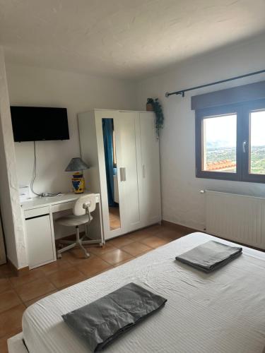 a bedroom with a bed and a desk and a window at Cozy vacation home in L’Alfàs del Pi