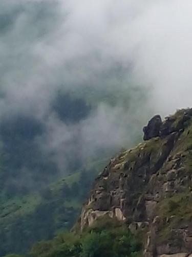 a mountain with clouds on top of it at Vardzia Chachkari Cottage in Gogasheni