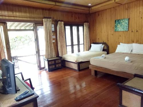 a bedroom with two beds and a television in it at Indie House @ Maerim in Chiang Mai