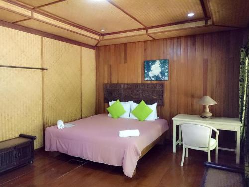 a bedroom with a bed and a table and a chair at Indie House @ Maerim in Chiang Mai