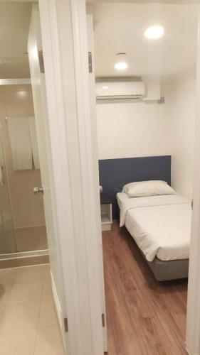 a small bedroom with a bed and a shower at Goodrich Hotel in Hong Kong