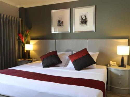 a bedroom with a large white bed with two pillows at Regent Park Hotel in Phnom Penh